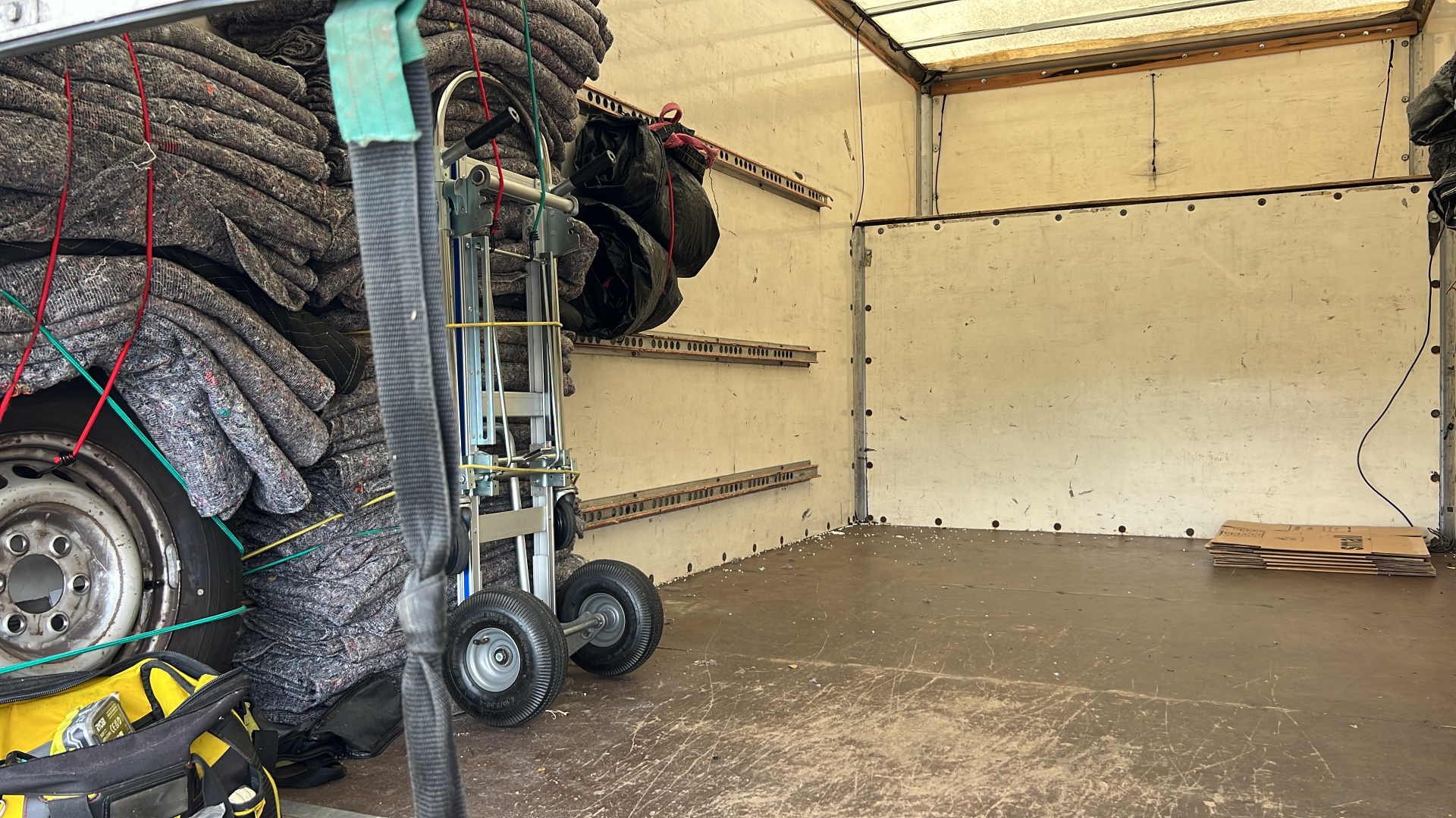Inside a removal van with blankets, trolley and tools
